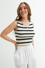 Musculosa corta de tejido de punto con rayas horizontales negras y blancas.