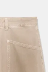 Jeans de tiro medio color beige claro, estilo baggy balloon, con cuatro bolsillos y trabillas en la cintura.