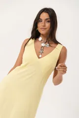 Vestido largo amarillo con escote en V y espalda con tirantes anchos. Confeccionado en lino imperial, con tajos a ambos costados y un diseño que entalla y realza la silueta.