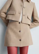 Minifalda color beige con cierre lateral y botones decorativos al frente.