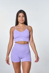 Conjunto deportivo lila compuesto por un top de tirantes con logo 'bk.' y un short de tiro alto. El top es de corte ajustado y tiene textura acanalada. El short es de corte ajustado y tiene cintura alta.