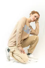 Pantalón de jogging color beige, con cintura elástica ajustable con cordón, bolsillos laterales y un bolsillo tipo cargo con solapa en la pierna derecha.