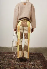 Pantalón de gabardina elastizada con estampado de parches en tonos marrón, amarillo y beige.