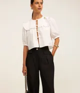 Pantalón de vestir negro, de corte wide leg, con cintura alta, bolsillos laterales y traseros.