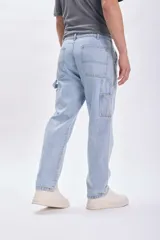 Pantalón de jean celeste, corte recto, estilo carpintero, con bolsillos laterales y traseros.
