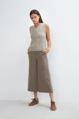 Chaleco tejido marrón con escote en v y sisas amplias. Diseño con diferentes puntos combinados en el frente.