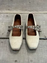 Ballerinas color arena con textura croco, tira sobre el empeine con hebilla y punta cuadrada.