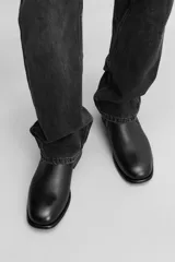 Bota Chelsea de cuero negro, con elásticos laterales, tirador trasero y suela con ligero tacón.