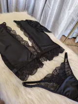 Conjunto negro de lycra, microtul y encaje suave elastizado. Incluye top con broche de gancho y espalda de microtul con detalles de encaje, y tanga regulable con forro de algodón.