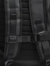 Mochila negra con cierre superior y bolsillo frontal con cierre. Tiene dos bolsillos laterales con cierre y un pequeño logo cuadrado en la parte inferior.