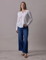 Camisa a rayas verticales color beige y gris, marca Alex & Jordan. Tiene cuello con solapa, abertura central con botones y bolsillo aplicado en el pecho.