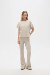 Pantalón gris de poliéster y lurex, holgado y de tiro alto, con textura acanalada.