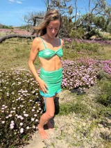 Minifalda verde brillante con frunces laterales y volados en el ruedo.