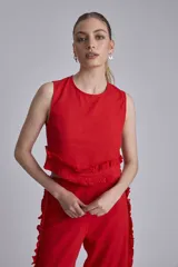 Conjunto de dos piezas color marrón, compuesto por un top sin mangas con volado en el ruedo y un pantalón ancho de tiro alto con volados decorativos a lo largo de las costuras laterales.