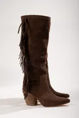 Botas altas de cuero gamuza color marrón, con punta fina, taco de madera y flecos decorativos en el lateral.