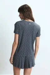 Conjunto de pijama de dos piezas, color gris oscuro, con estampado de pequeños motivos blancos. Incluye una remera de manga corta y un short.
