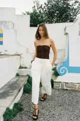 Top bustier marrón de lino con escote recto, hombros descubiertos, detalle de frunces, falsos botones delanteros y nido de abeja elástico en la espalda.