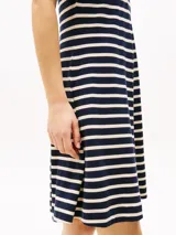 Vestido corto de corte evasé a rayas horizontales azul marino y blancas, con cuello tipo chomba azul marino y mangas cortas.