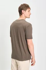 Remera verde de manga corta con cuello redondo y tapeta con tres botones.