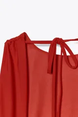 Top rojo de cuello redondo y tirantes anchos. Detalle de escote en espalda con tira cruzada ajustable con lazada.