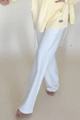 Pantalón blanco de jersey, corte amplio, con bolsillos laterales y cintura elastizada con cordón ajustable.