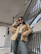 Campera de pana color beige con cierre frontal y cuello negro.