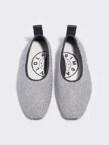 Bailarina plateada de punta fina, confeccionada en tejido de punto con espumillón. Cuenta con forro, tirador trasero de cuero, plantilla logotipada y suela con logo.