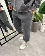 Conjunto deportivo gris con efecto lavado, compuesto por un hoodie con capucha, bolsillo canguro y logo "Bohemian Design" estampado en el pecho, y un pantalón jogging de corte holgado.