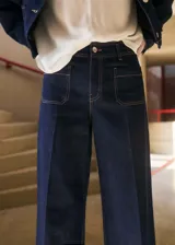 Pantalón de jean azul oscuro, corte wideleg, tiro alto, con bolsillos delanteros de parche y cierre frontal con cremallera y botón.