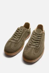 Zapatillas de cordones color verde oliva, de estilo retro. Parte superior fabricada en piel con acabado serraje y suela en contraste color caramelo.