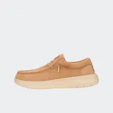 Mocasín Hey Dude modelo Wally Comf Suede, color camel o beige claro, confeccionado en gamuza con costuras visibles en el empeine. Posee un sistema de cordones elásticos y una suela gruesa y elevada de color crema.