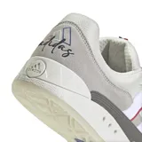 Championes Adidas Adimatic color gris claro con detalles en gris oscuro y blanco. Presentan las tres tiras características de Adidas en blanco con bordes en azul y rojo.