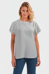 Remera gris con detalle de bordado calado en cuello y mangas cortas.