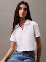 Remera corta de algodón blanco con textura acanalada, cuello polo con abertura y logo CK bordado en el pecho.