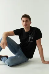 Remera negra de algodón con estampado en el frente y la palabra "CONNECT" estampada verticalmente en blanco en el lateral izquierdo.