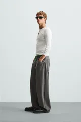 Pantalón de jean gris de corte amplio, estilo balloon fit, con cinco bolsillos, cierre frontal con cremallera y botón, y efecto de color lavado en toda la prenda.