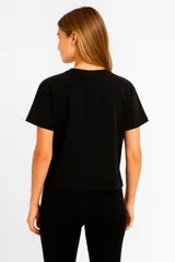 Remera blanca de manga corta con estampa de flor negra, texto y números.