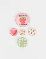 Set de cinco pines redondos con diferentes diseños: fresa con texto "I love you berry much", corazón sonriente, texto "Life is great" sobre fondo a cuadros, fresas sobre fondo crema, y texto "Each day is a fresh start" sobre fondo a cuadros verde y blanco.
