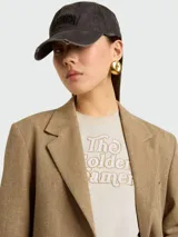 Remera color crema con estampa marrón que dice "The Golden Dreamers".