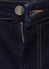 Pantalón de jean azul oscuro, de tiro alto, corte crop y acampanado. Cuenta con cierre de cremallera y botón, trabillas, cinco bolsillos y tejido elástico.