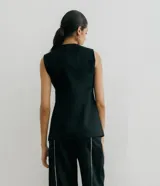 Chaleco sastrero color crema de lino, con cuello en V profundo y cierre cruzado con botón.