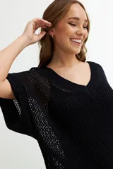 Vestido de playa negro de tejido calado con mangas cortas y escote en V.