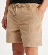 Bermuda masculina tipo runner color beige, confeccionada en terciopelo acanalado, con cintura elástica, cordón de ajuste y bolsillos laterales.