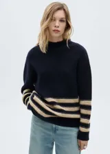 Sweater azul marino con cuello perkins y diseño de rayas horizontales color beige.