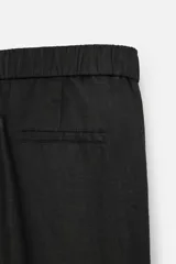 Pantalón negro regular fit confeccionado en tejido de lino. Cintura ajustable con cordón interior, bolsillos frontales y detalle de bolsillos traseros de vivo.