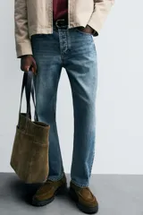 Pantalón de jean celeste de corte recto, con cinco bolsillos, efecto lavado y cierre frontal con botones.