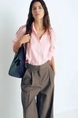 Camisa rosa de lino liviano, de corte recto, con cuello clásico, botones frontales, manga larga con puños abotonados, canesú en la espalda, bolsillo de parche en el pecho y bajo redondeado.