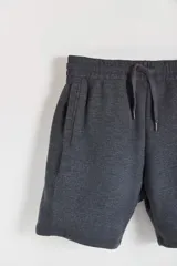 Bermuda deportiva gris melange con cintura elástica y cordón ajustable.