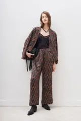 Conjunto de pantalón y kimono con estampado floral en tonos rojo y dorado sobre fondo negro. El pantalón es de corte palazzo con cintura elástica. El kimono es de mangas anchas y corte holgado.