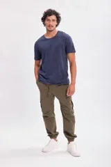 Pantalón cargo jogger verde militar con bolsillos laterales y tobillos ajustados.